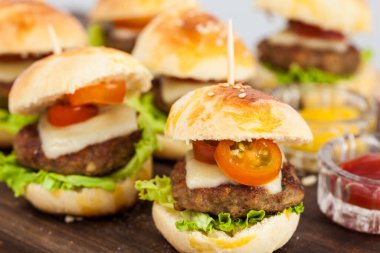 Mini hamburger servis etmeye hazır. Adım adım mini burgerleri hazırlıyorum. Çocuklar ve aperatifler için ev yapımı mini burgerler. Küçük hamburgerler..