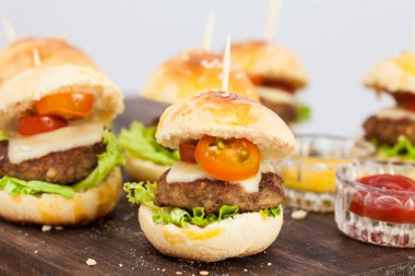 Mini hamburger servis etmeye hazır. Adım adım mini burgerleri hazırlıyorum. Çocuklar ve aperatifler için ev yapımı mini burgerler. Küçük hamburgerler..