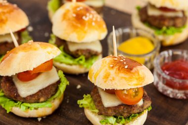 Mini hamburger servis etmeye hazır. Adım adım mini burgerleri hazırlıyorum. Çocuklar ve aperatifler için ev yapımı mini burgerler. Küçük hamburgerler..