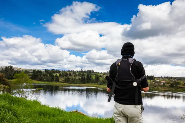 Male tourist taking photos at an artificial lake in the region of  Boyaca in Colombia. La Playa reservoir located at the Tuta Municipality in Boyaca.