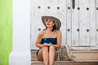 Cartagena de Indias 'ın tarihi sokaklarında Sombrero Vueltiao adında geleneksel Kolombiya şapkası takan güzel bir kadın.