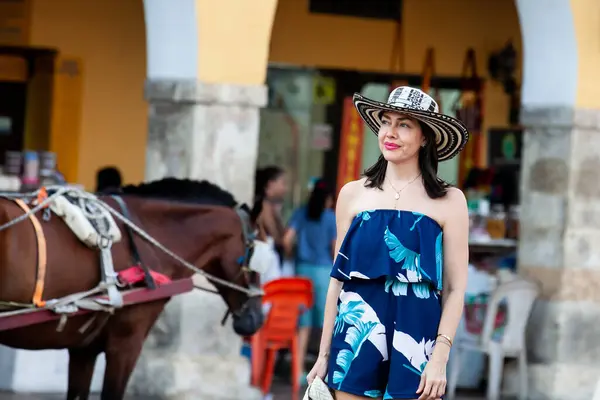 Beautiful woman wearing the traditional Colombian hat called Sombrero Vueltiao at the Carriage Square on the historical streets of Cartagena de Indias walled city