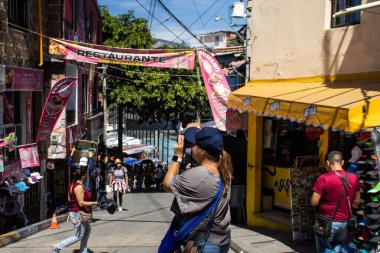 MEDELLİN, COLOMBIA - 17 HAZİRAN 2024: Medellin 'deki ünlü Comuna 13' te güneşli bir günde fotoğraf çeken kadın turist