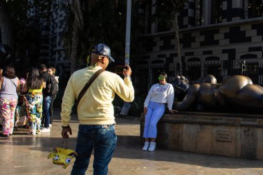 MEDELLİN, COLOMBIA - 17 HAZİRAN 2024: Medellin 'de ünlü Kolombiyalı sanatçı Fernando Botero tarafından yapılan bronz heykelleri ziyaret eden turistler.