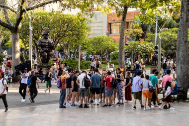 MEDELLİN, COLOMBIA - 17 HAZİRAN 2024: Medellin 'de ünlü Kolombiyalı sanatçı Fernando Botero tarafından yapılan bronz heykelleri ziyaret eden turistler.