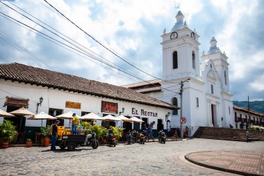 GUADUAS, COLOMBIA - JANUARY 12, 2024: View of the beautiful streets around the central square of the Heritage Town of Guaduas located in the Department of Cundinamarca in Colombia. clipart