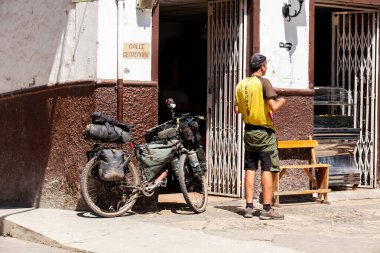 SALAMINA, COLOMBIA - 14 HAZİRAN 2024: Bisiklet Gezgini Salamina 'nın miras kasabasının merkez meydanındaki bir mağazanın yanında.