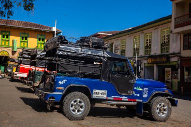 Kolombiya 'nın Caldas bölgesinde bulunan tarihi miras kasabası Aguadas' ın merkez meydanındaki renkli geleneksel araçlar..