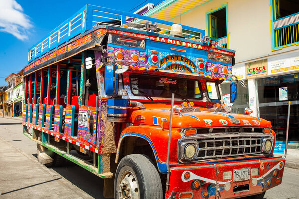 АГУАДАС, КОЛОМБИЯ - 15 ЯНВАРЯ 2024: Традиционный колумбийский красочный сельский автобус под названием Чива, припаркованный на красивых улицах города Агуадас в Колумбии.