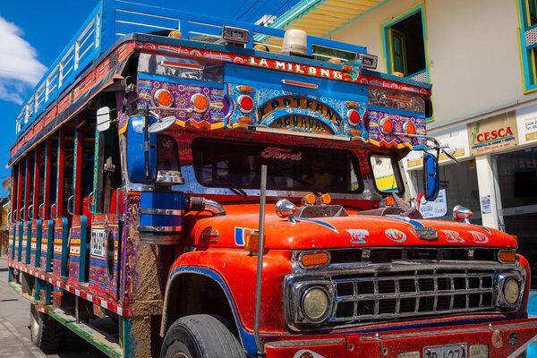 АГУАДАС, КОЛОМБИЯ - 15 ЯНВАРЯ 2024: Традиционный колумбийский красочный сельский автобус под названием Чива, припаркованный на красивых улицах города Агуадас в Колумбии.