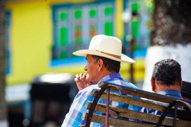 AGUADAS, COLOMBIA - 15 HAZİRAN 2024: Kolombiya 'da bulunan geleneksel şapkayı takan Aguadas' ın merkez meydanındaki yerel yaşlılar.