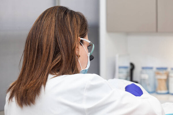 Дерматолог проводит биопсию кожи на лице пожилого пациента