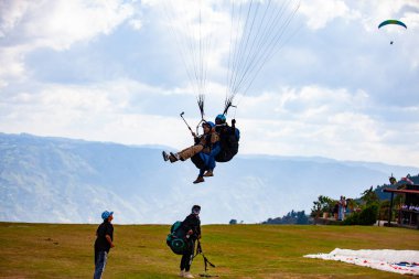 Barbosa, Antioquia, Kolombiya - 21 Ocak 2024: Kolombiya 'daki Antioquia departmanının güzel dağları üzerinde yamaç paraşütü yapan insanlar. İniş