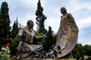 Mexico City, Mexico - October 27, 2024: Statue of Juan Diego showing the image of the Virgin of Guadalupe to Bishop Juan de Zumarraga on Tepeyac Hill in Mexico City. clipart