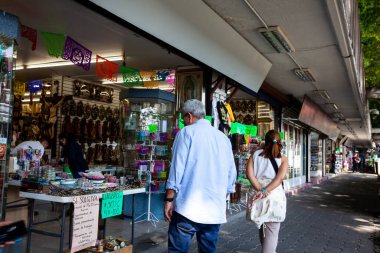 Mexico City, Mexico - 16 Eylül 2024: Mexico City 'deki Guadalupe Bakire Bazilikası' nın yanındaki dini eşya dükkanlarına bakan birkaç kıdemli turist