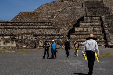 Meksika Eyaleti, Meksika - 24 Ekim 2024: Teotihuacan arkeoloji sahasında turist rehberleri ve turistler güzel mavi bir gökyüzü gününde. Ölüler Bulvarı 'ndan Ay Piramidi.
