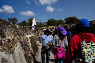 Meksika Eyaleti, Meksika - 24 Ekim 2024: Teotihuacan arkeoloji sahasında turist rehberi ve turistler güzel mavi bir gökyüzü gününde. Kelebekler Sarayı.