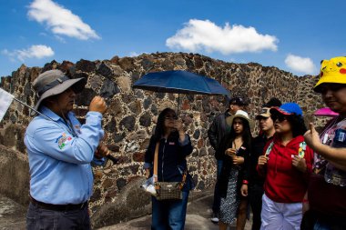Meksika Eyaleti, Meksika - 24 Ekim 2024: Teotihuacan arkeoloji sahasında turist rehberi ve turistler güzel mavi bir gökyüzü gününde. Kelebekler Sarayı.