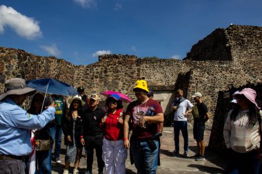 Meksika Eyaleti, Meksika - 24 Ekim 2024: Teotihuacan arkeoloji sahasında turist rehberi ve turistler güzel mavi bir gökyüzü gününde. Kelebekler Sarayı.