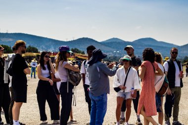 Meksika Eyaleti, Meksika - 24 Ekim 2024: Güzel mavi gökyüzü gününde Teotihuacan arkeoloji sahasında rehberli bir grup turist. Ölüler Bulvarı.