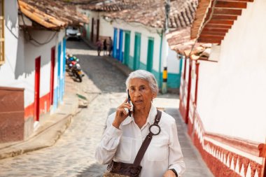 Telefonda konuşan şaşırmış bir suratı olan son sınıf öğrencisi. Kolombiya 'daki Antioquia Bölümü' nde bulunan güzel Concepcion koloni kasabasında kıdemli bir kadın..