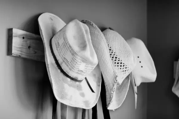 Duvarda saman kovboy şapkaları asılı.