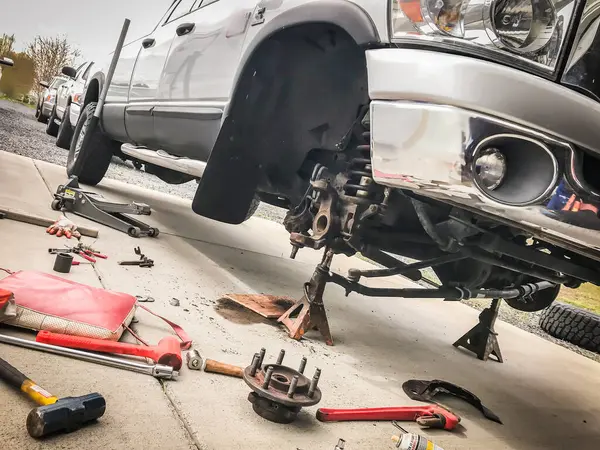 Tekerleği sökülmüş kamyonetin ön ucu tamir ediliyor.