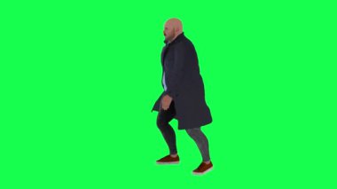 Yeşil ekranda donanma paltosu içinde hızlı yürüyen şişman bir adam.