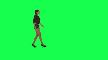Kahverengi elbiseli, siyah şortlu, yüksek topuklu giyen yeşil ekranda parkta yürüyen güzel bir kadın.