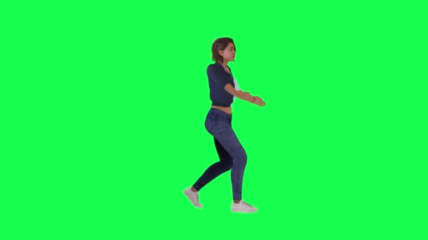 快乐的女人穿着白色的蓝色衣服 黑色的裤子和白色的鞋子在派对上从左边的角度在绿色的屏幕上跳桑巴 — 图库视频影像