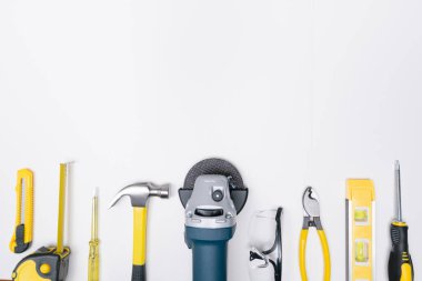 Top view selective focus grinder and construction DIY tools on white background.
