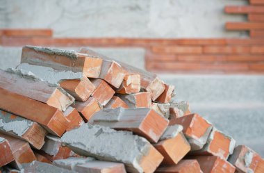 turuncu kahverengi tuğla yığını. İnşaatın dış cephesi boş. Yapı malzemelerinin yenilenmesi arka planı, antika ya da eski tarz duvar kağıdı tasarımı..