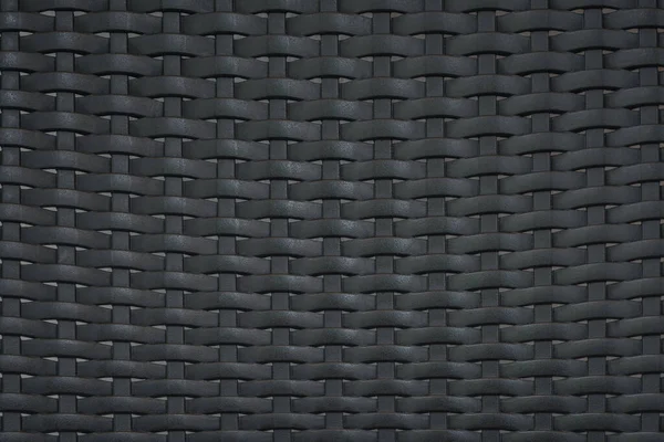 Siyah plastik rattan modern mobilya malzemesinin yakın şablonu. Duvar kağıdı tasarımı fikri..