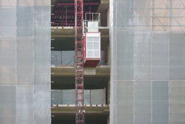 Kaldıraç asansörüyle beton malzeme yapısı inşa eden modern mimari yapı. Yeni endüstri teknolojisi inşaat projesi kavramı..