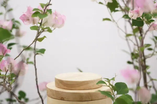 empty wooden podium blurred pink  flowers decoration on white background with space.beauty cosmetic and romantic valentines or mother,birthday woman love gift product pedestal platform stand display.