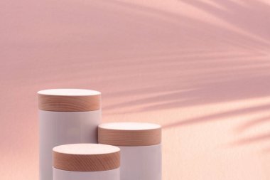 Bulanık tropikal palmiye yaprağı gölgesi olan minimum podyum masa üstü zemini. Pembe pastel arka plan. Kozmetik güzellik, doğal ürün yerleştirme tezgahı. Orman ormanı yaz cenneti kavramı..