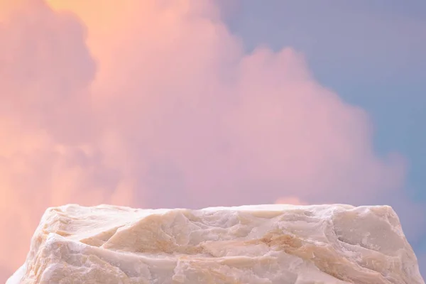 Gökyüzünde açık havada taş podyum masası zemininde pembe altın pastel yumuşak bulut bulanık zemin. Güzellik kozmetik ürünleri yerleştirme sunum tezgahı. Yaz cenneti rüya gibi konsept..