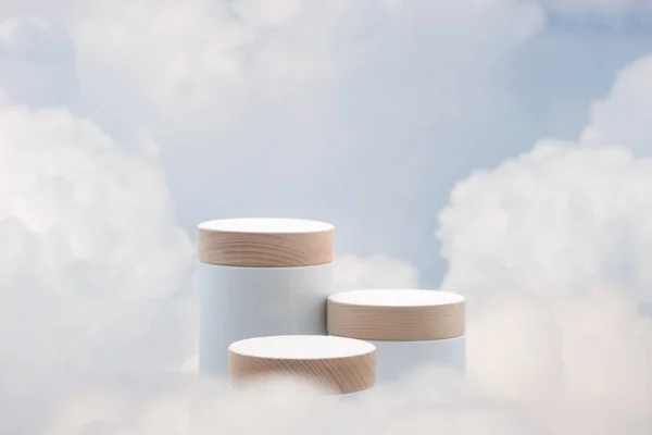 Mavi gökyüzünde gerçeküstü podyum. Boşluğu olan yumuşak beyaz bulutlar. Güzellik ürünleri yerleştirme sunumu..