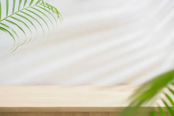 Beyaz uzay arka planında ahşap masa üstü mavisi yeşil yaprak palmiyesi. Güzellik kozmetik ürünü sergileniyor..