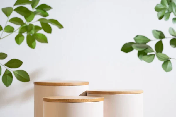 Minimal wood white podium with blurred green leaf plant on isolated background.Beauty cosmetic natural mild product modern display,nature eco friendly concept.