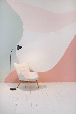 Pink chair near abstract wall in loft design