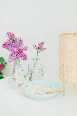 İskandinav lambasıyla dekorasyon masasında beyaz ve mor leylak. Yüksek kalite fotoğraf
