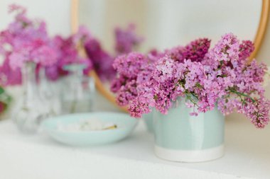 Mavi vazolarda mor leylak, altın aynalı güzel bahar ilham çiçekli. Yüksek kalite fotoğraf