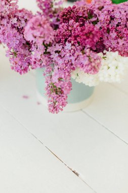 Çiçekçinin beyaz zemininde mavi vazoda beyaz ve mor leylak. Yüksek kalite fotoğraf