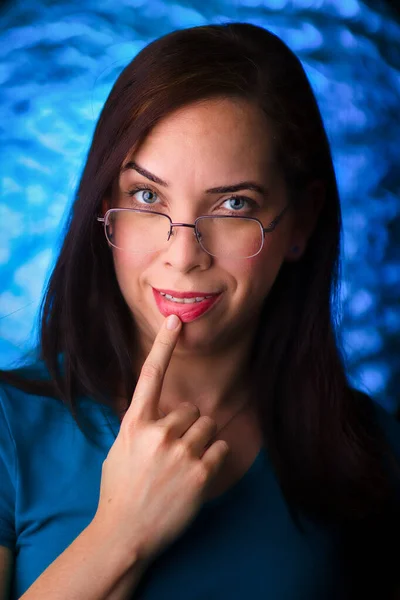 sexy woman touching her lip. High-quality photo. Blue background