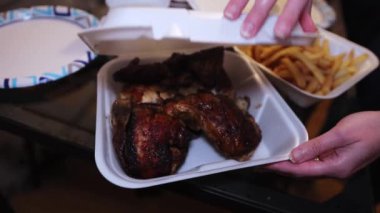 Roasted whole chicken on disposable plate with French fries
