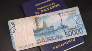 Salvadoran passport with Indonesian money ready to use when traveling to Indonesia