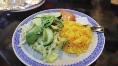 Salmon, rice, avocado, cheese, cabbage and cucumber salad on a large plate for dinner