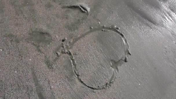 Coração Desenhado Areia Está Sendo Lavado Pelas Ondas Dia Ensolarado — Vídeo de Stock