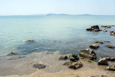 Yazın güneşli bir günde Bulgaristan 'ın Sarafovo kenti yakınlarındaki bir sahildeki sakin sığ sularda kayalar var. Yatay panoramik resim